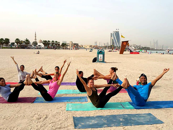 Group practising yoga at the beach
